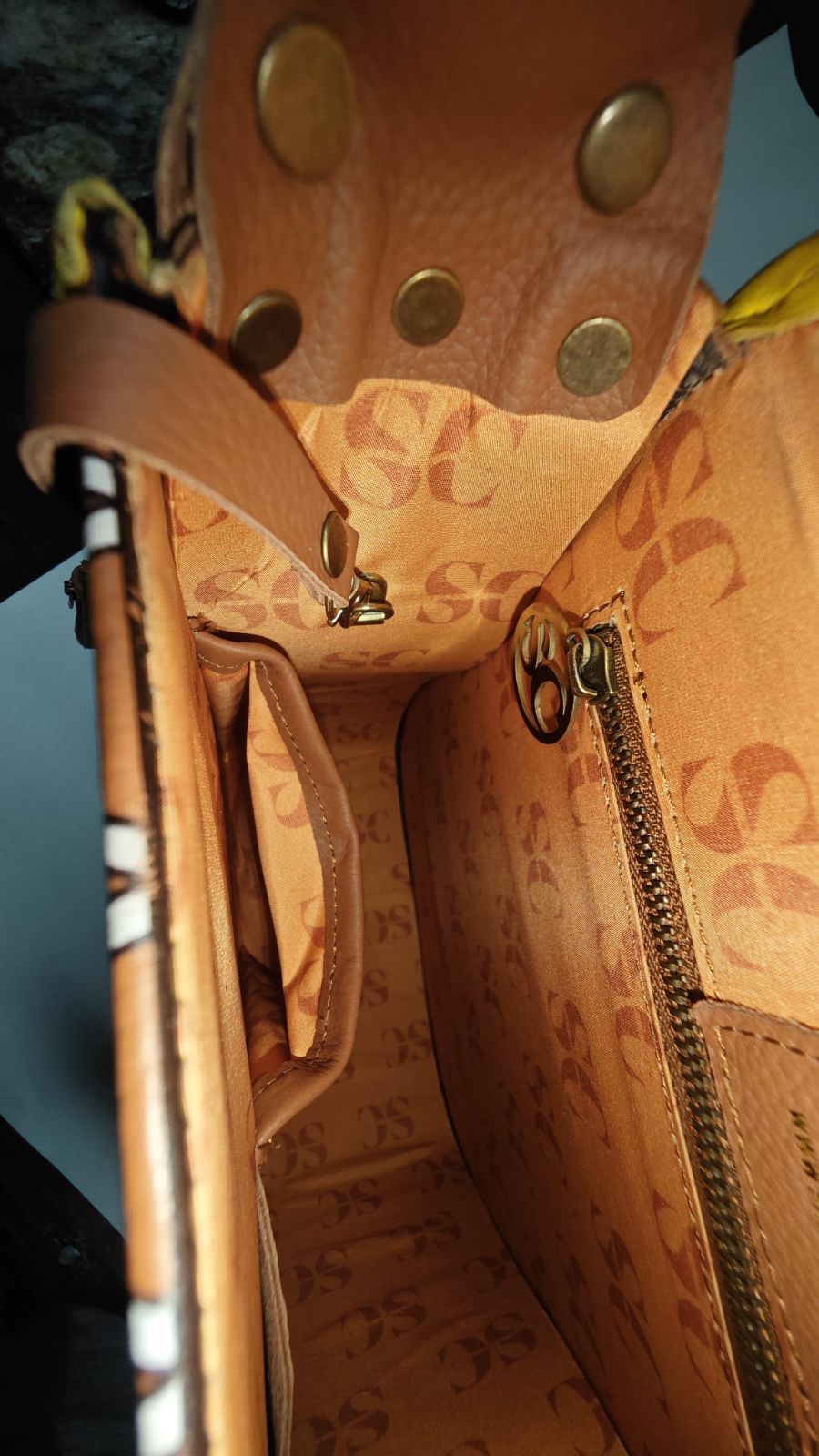 Earthsong Puff Bag interior with SC monogram lining, a zipped storage pocket and leather strap attachments.