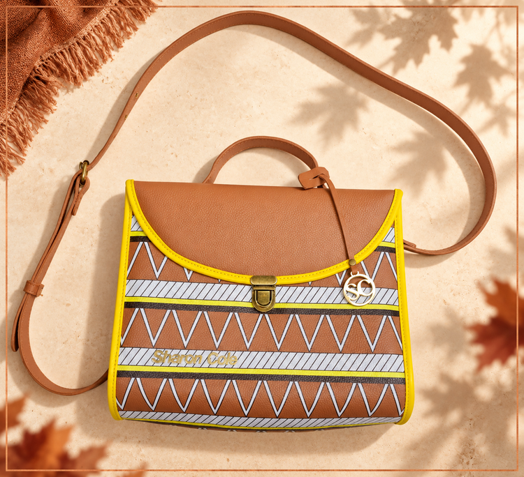 Earthsong style 001 brown shoulder handbag on pale ivory stone with soft autumn leaf shadows, a copper frame and rust linen styling.