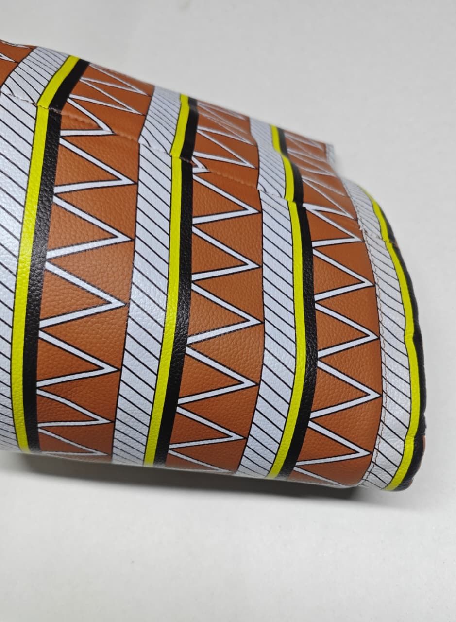 Close-up of the Nefertiti hat’s brown genuine leather and geometric tribal print with white, black and yellow bands.