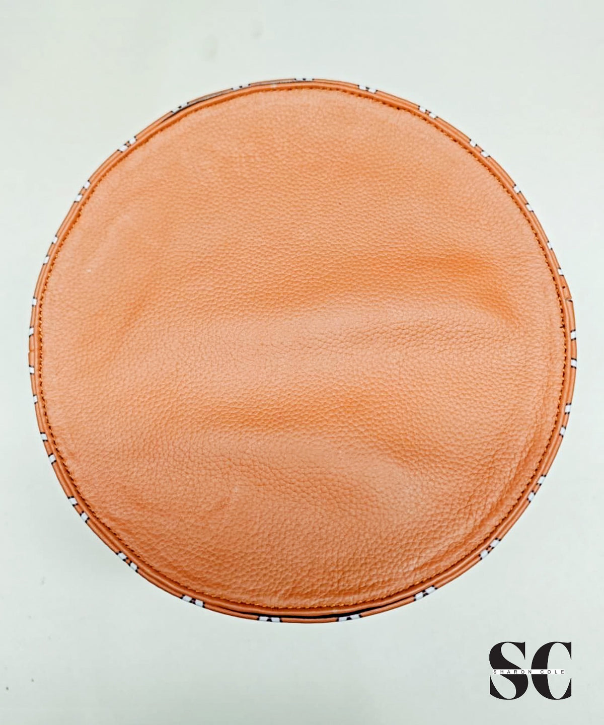 Top view of the Nefertiti statement hat showing its plain brown leather crown and stitched edge.
