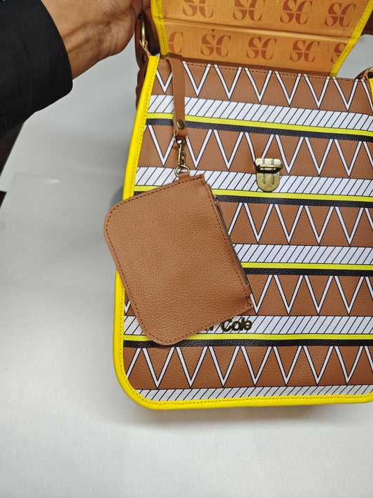 Open Earthsong Puff Bag showing its tribal-print front, gold-tone clasp, SC lining and attached brown leather change purse.